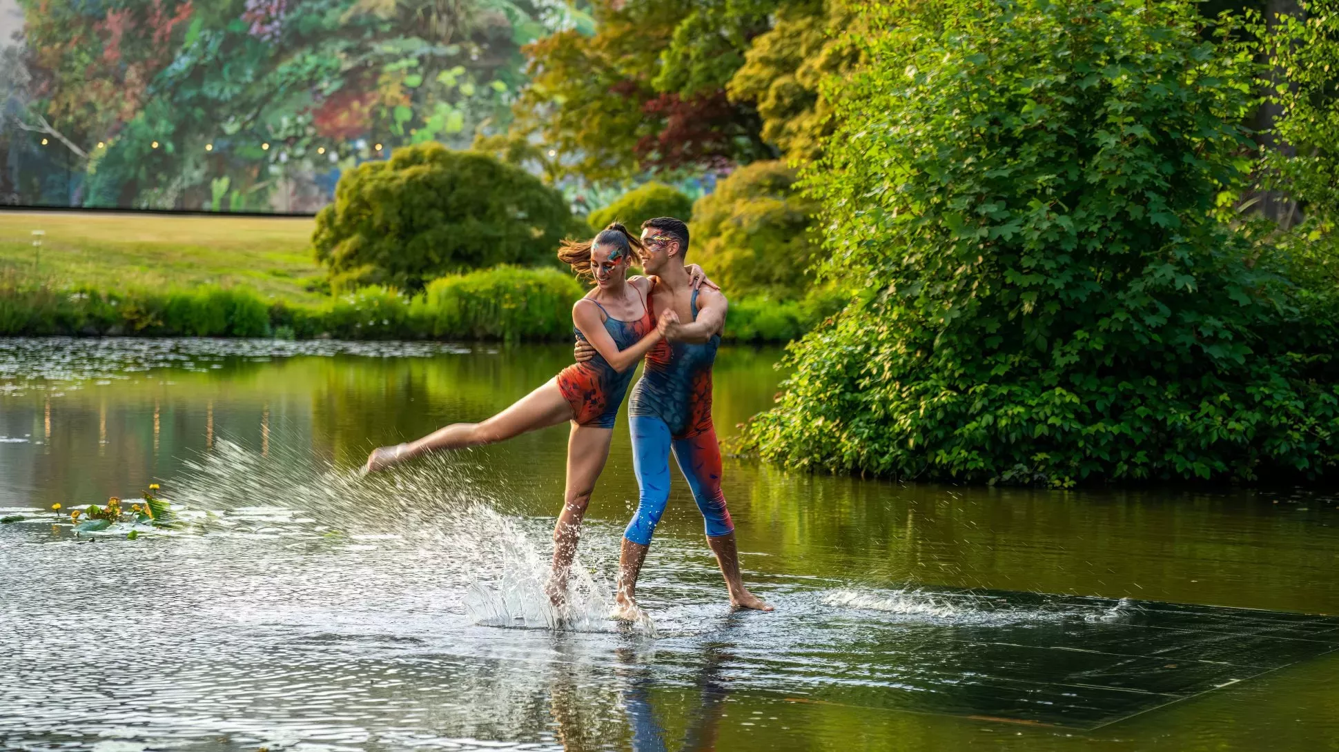 A pair of people dancing on the surface of a pond