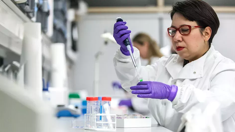 Scientist in a laboratory holding a pipette