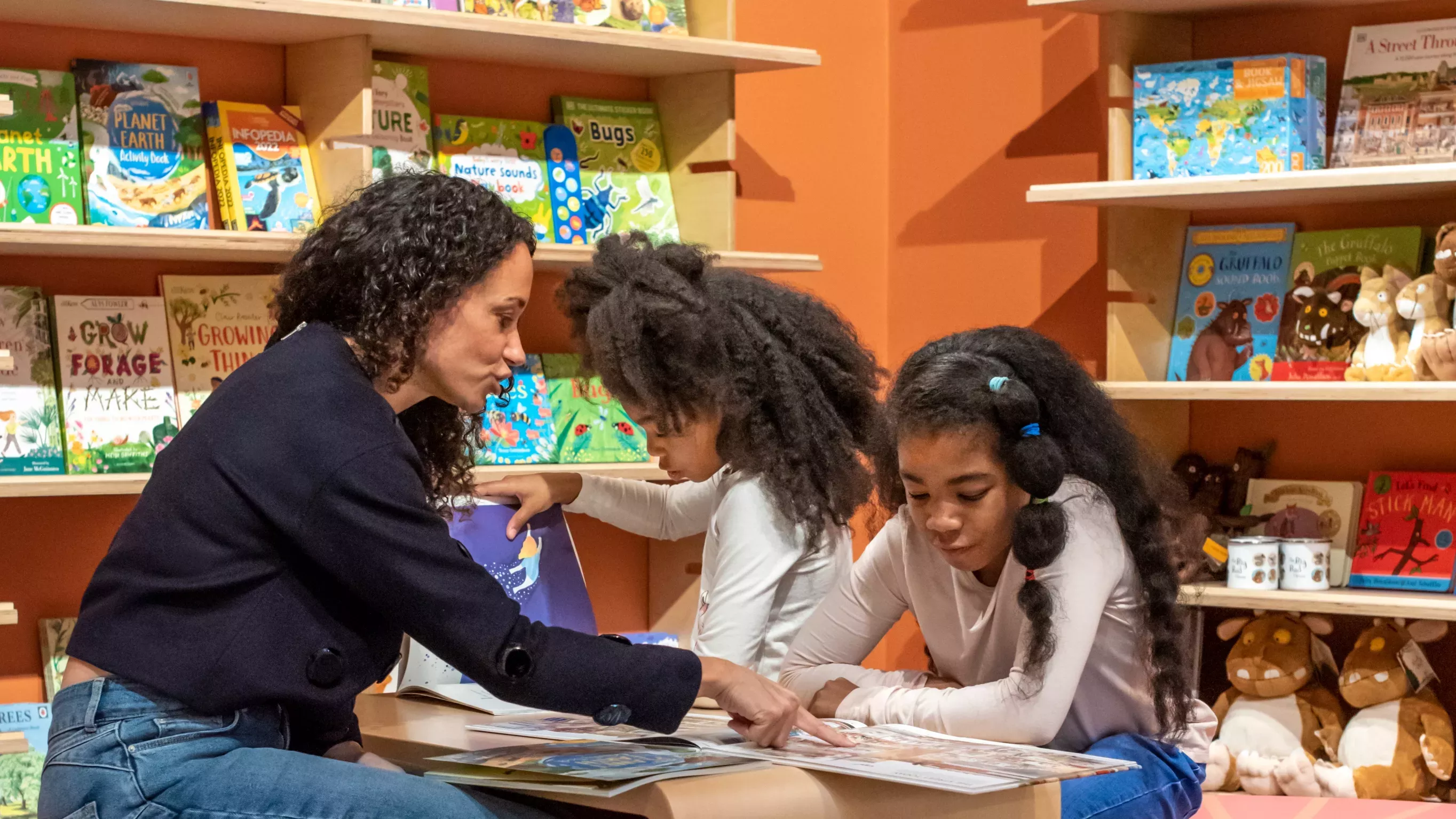 Family reading and interacting with items sold in the Family Kitchen & Shop