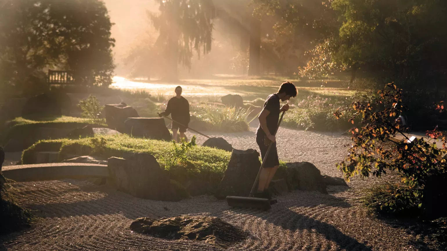 Horticulturists raking the gravel in the Japanese Landscape at Kew