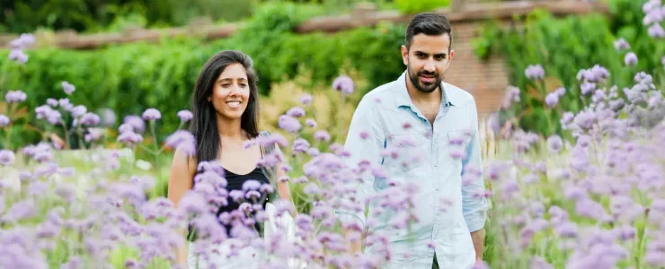 A couple walks through purple flowers