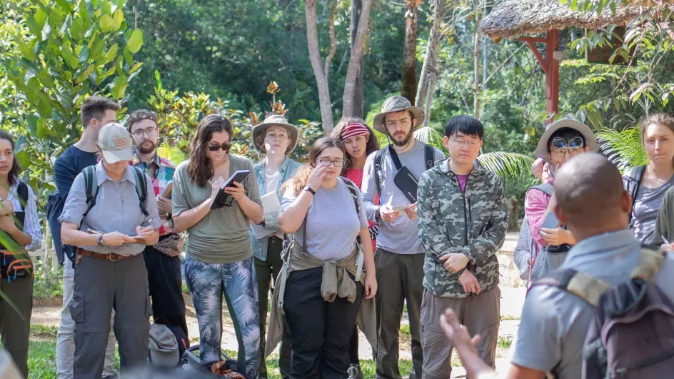 MSc students on the Madagascar fieldtrip stood in a line looking at researcher giving a talk