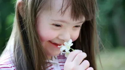 Young girl smelling a flower