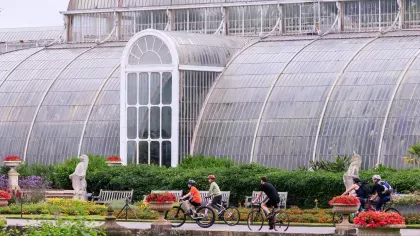 People on bikes outside a large glasshouse