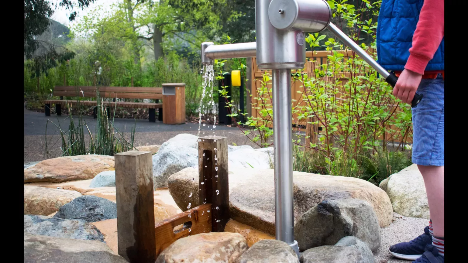 A child pumps water in the the Children's Garden