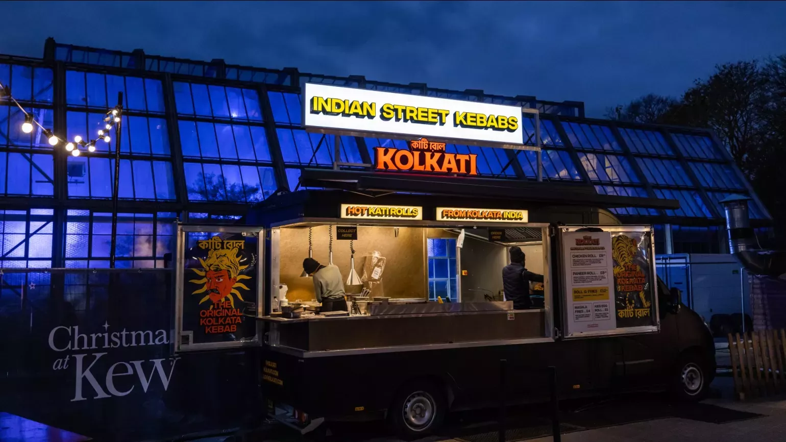 A street food stand at night serving Indian kebabs