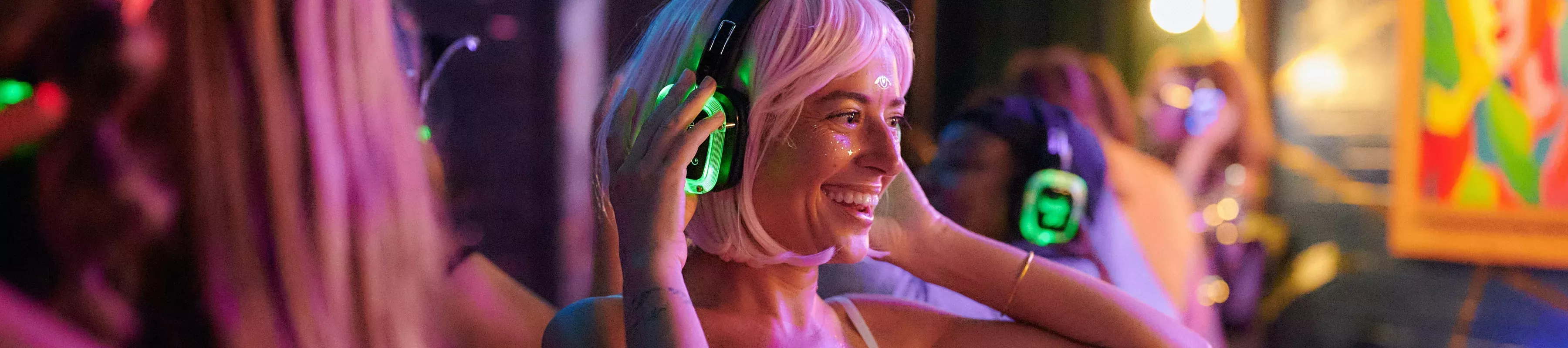 Smiling woman wearing headphones and face glitter