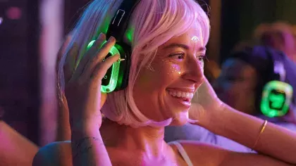 Smiling woman wearing headphones and face glitter