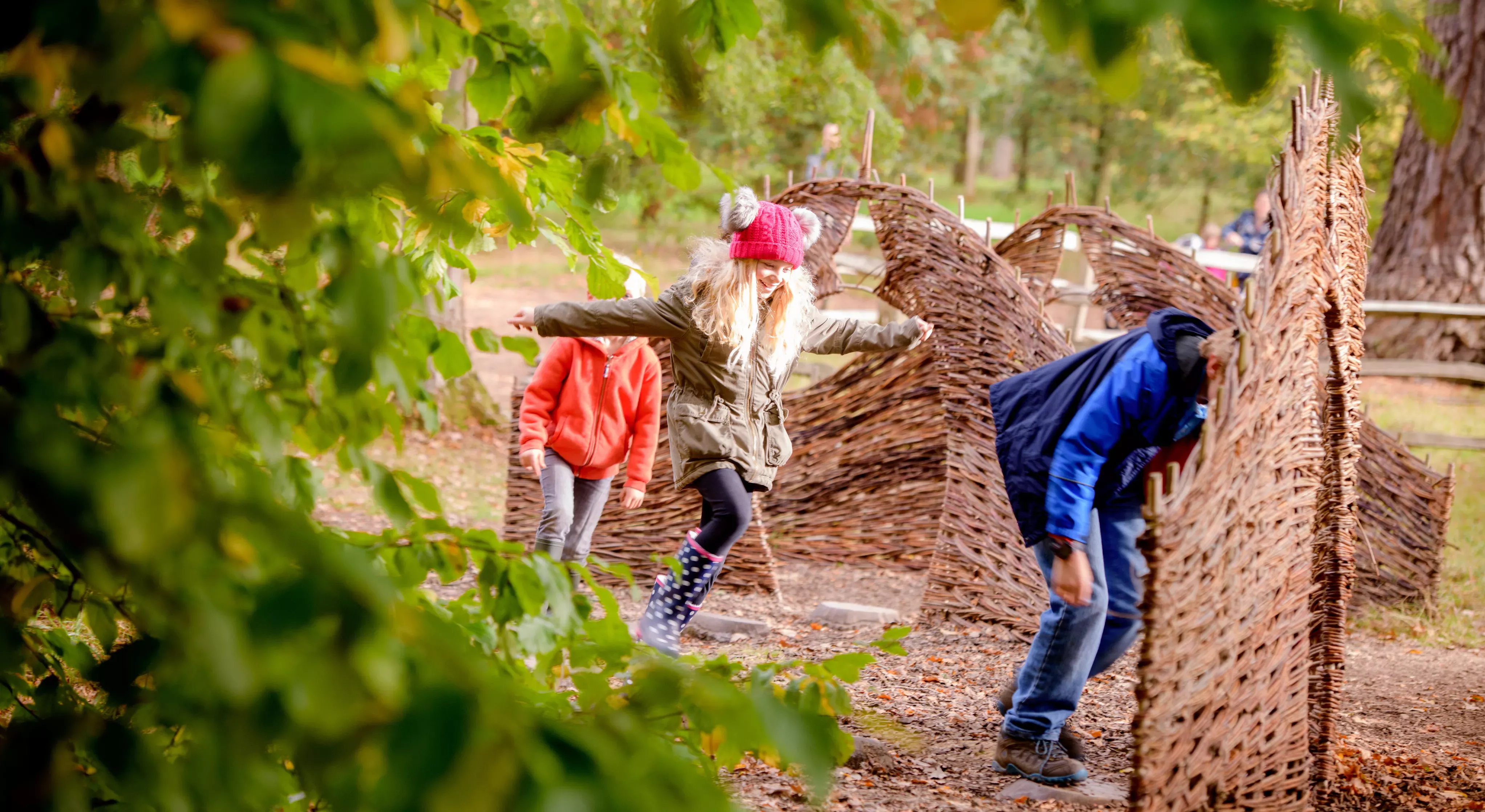 Children running through a woodland playground