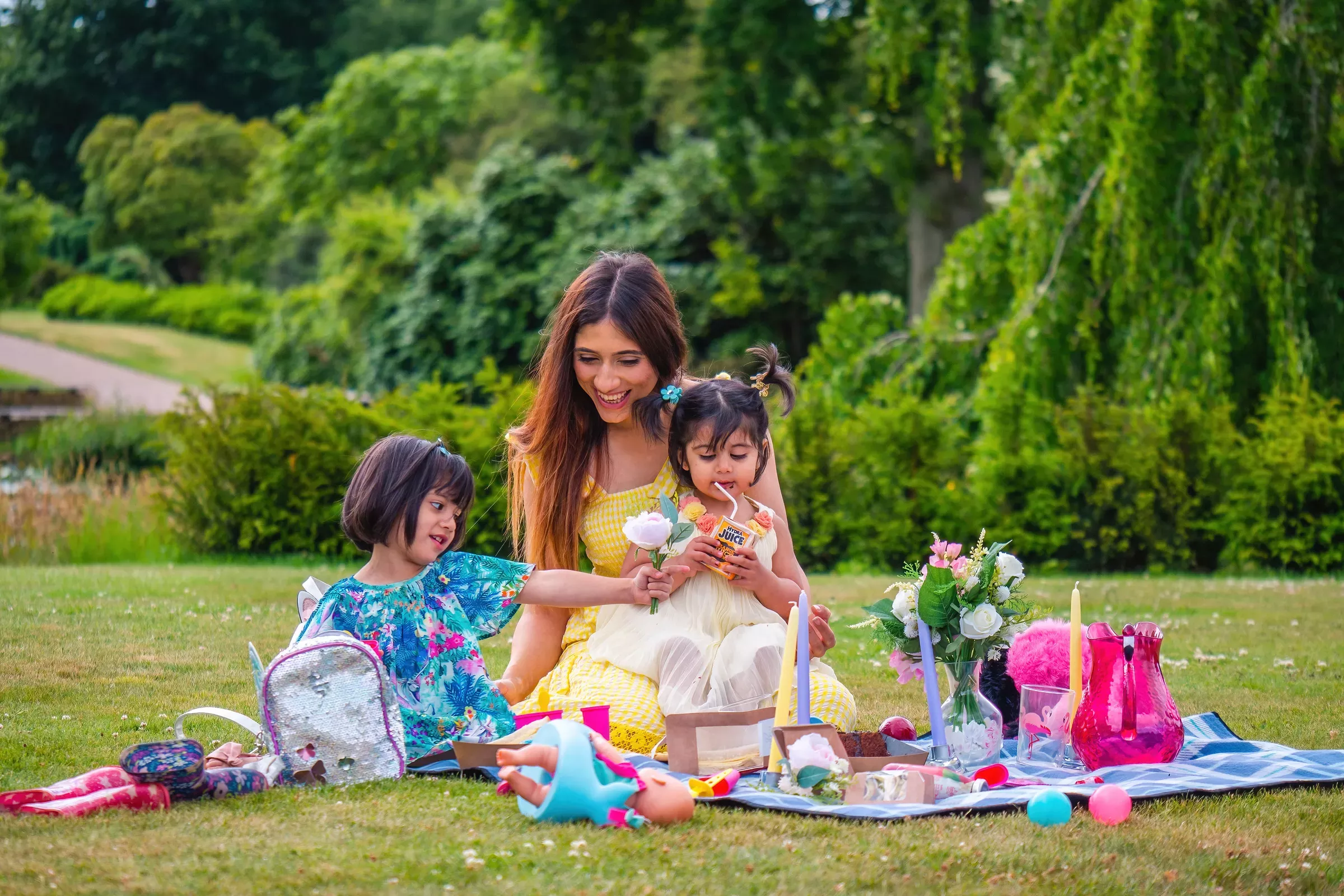 A family have a picnic in the gardens at Wakehurst