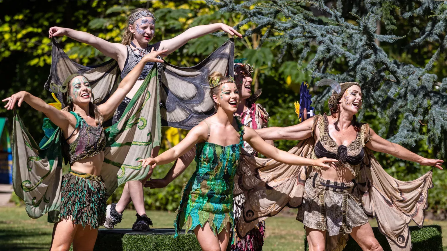 A group of fairies dance outside in nature