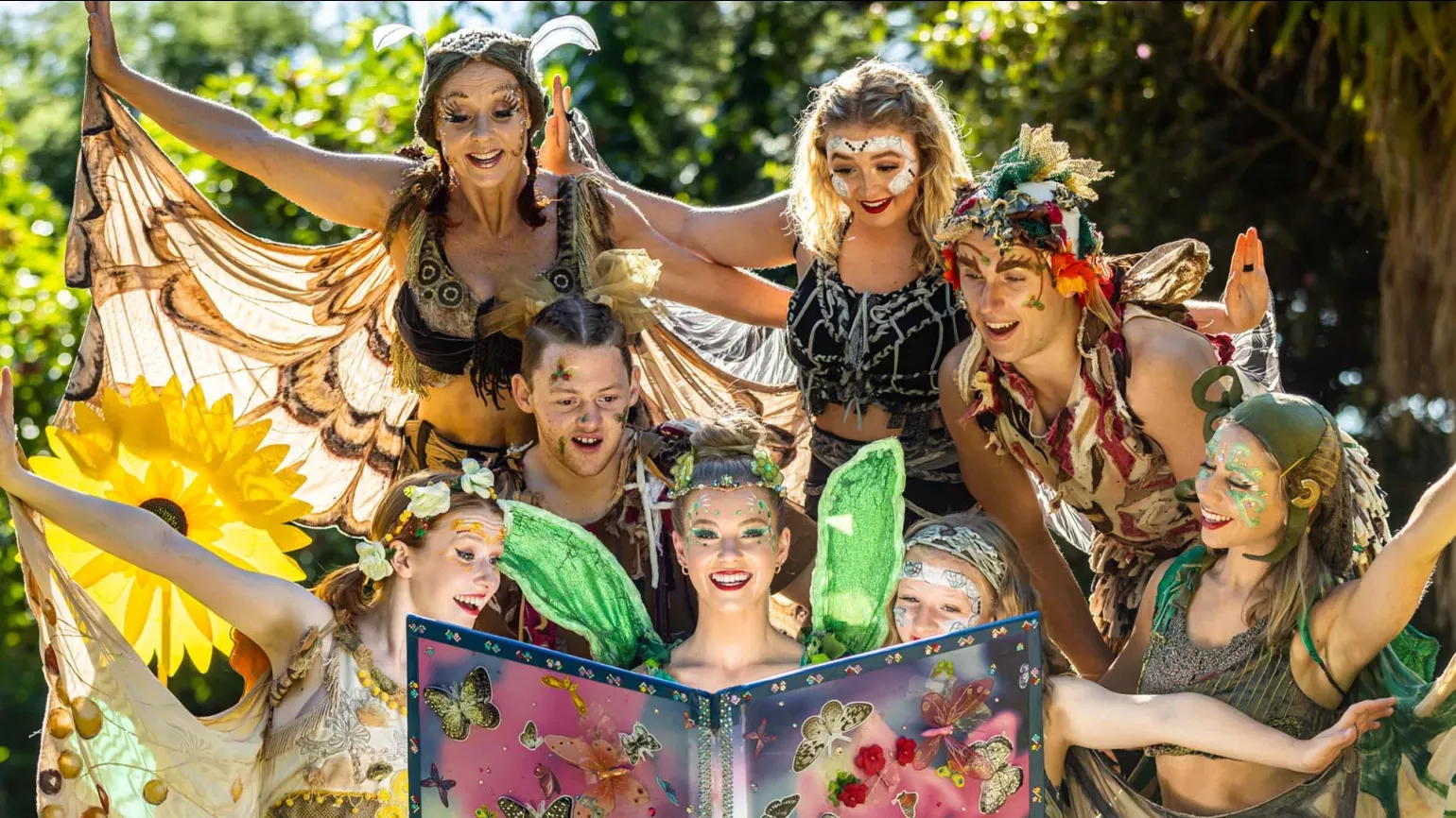 A group of fairies gathered around a book