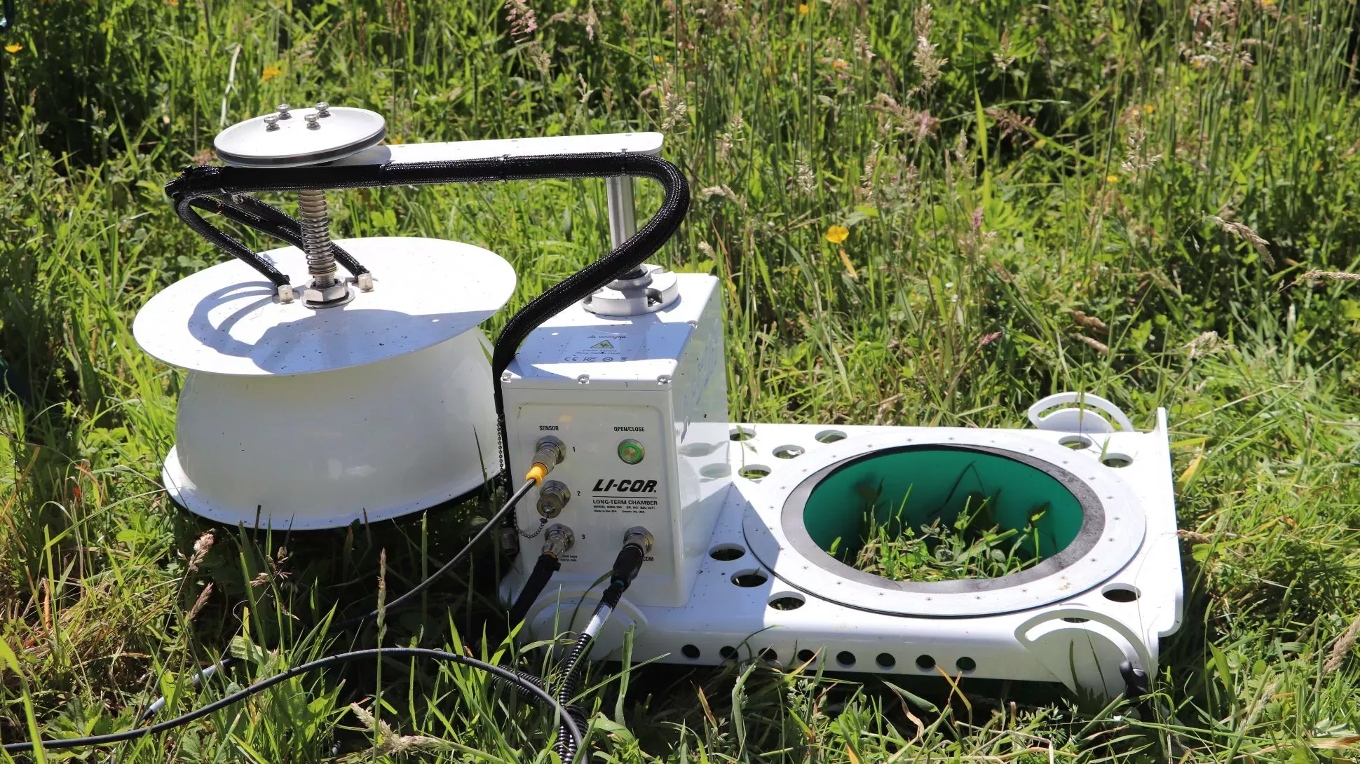 A piece of white scientific machinery in a field