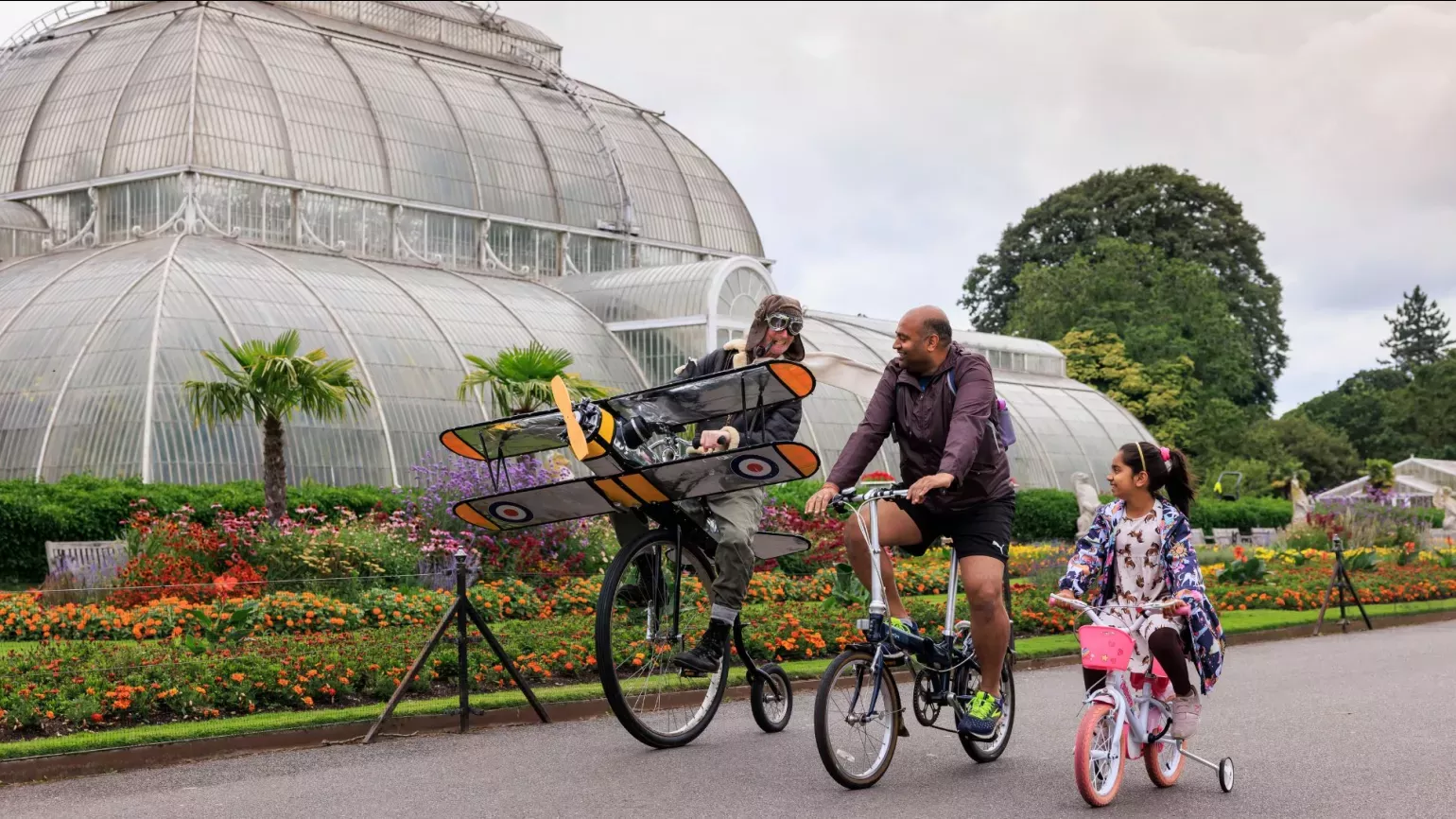 People on bikes outside a large glasshouse