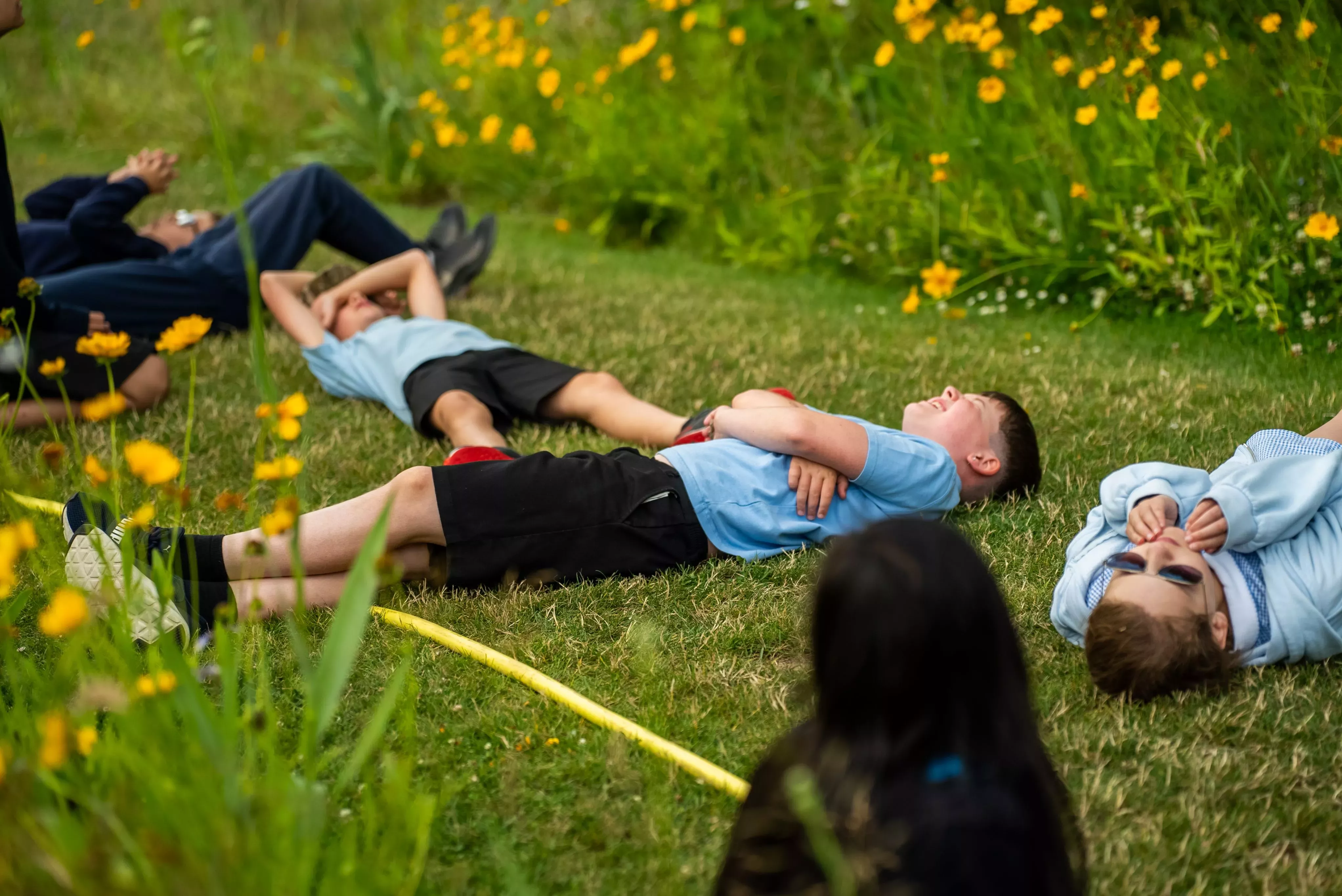 Schoolkids lying on the grass