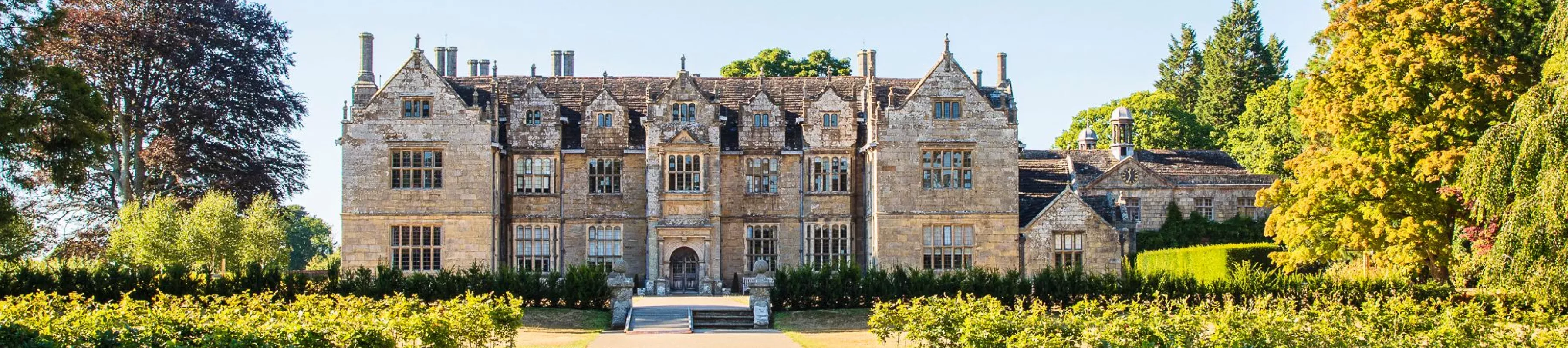 A wide shot of the Wakehurst mansion in summer