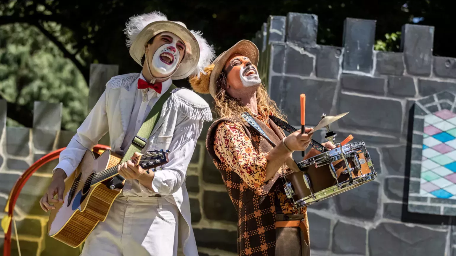 A pair of face painted people playing instruments