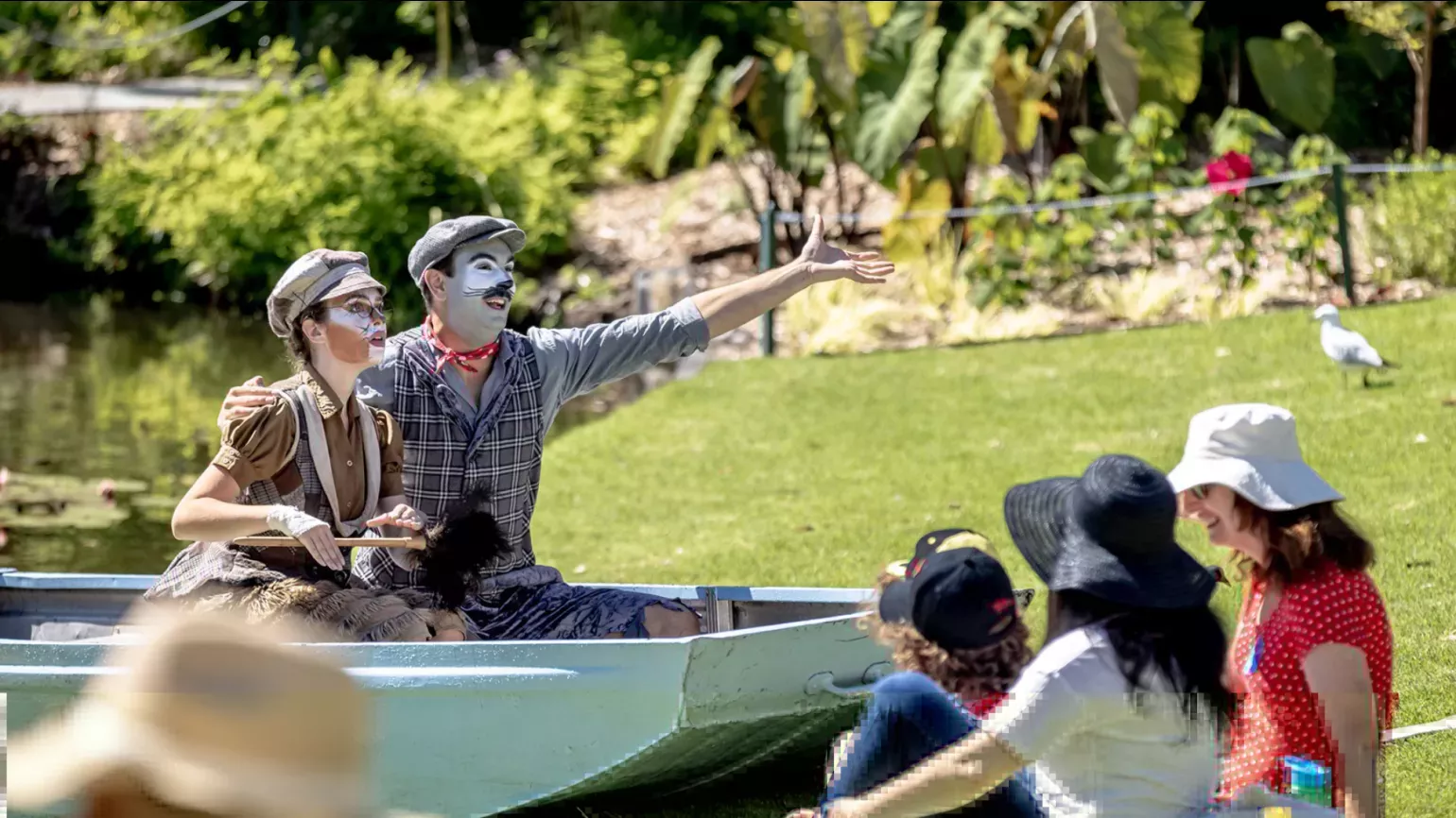 A pair of performers point from a boat